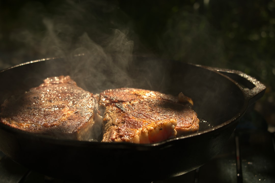Cast iron skillet searing a steak