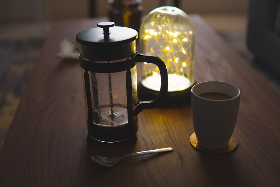 French press with coffee on table