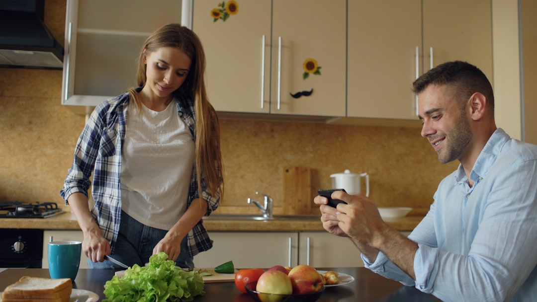 Woman cooking with smartphone in kitchen