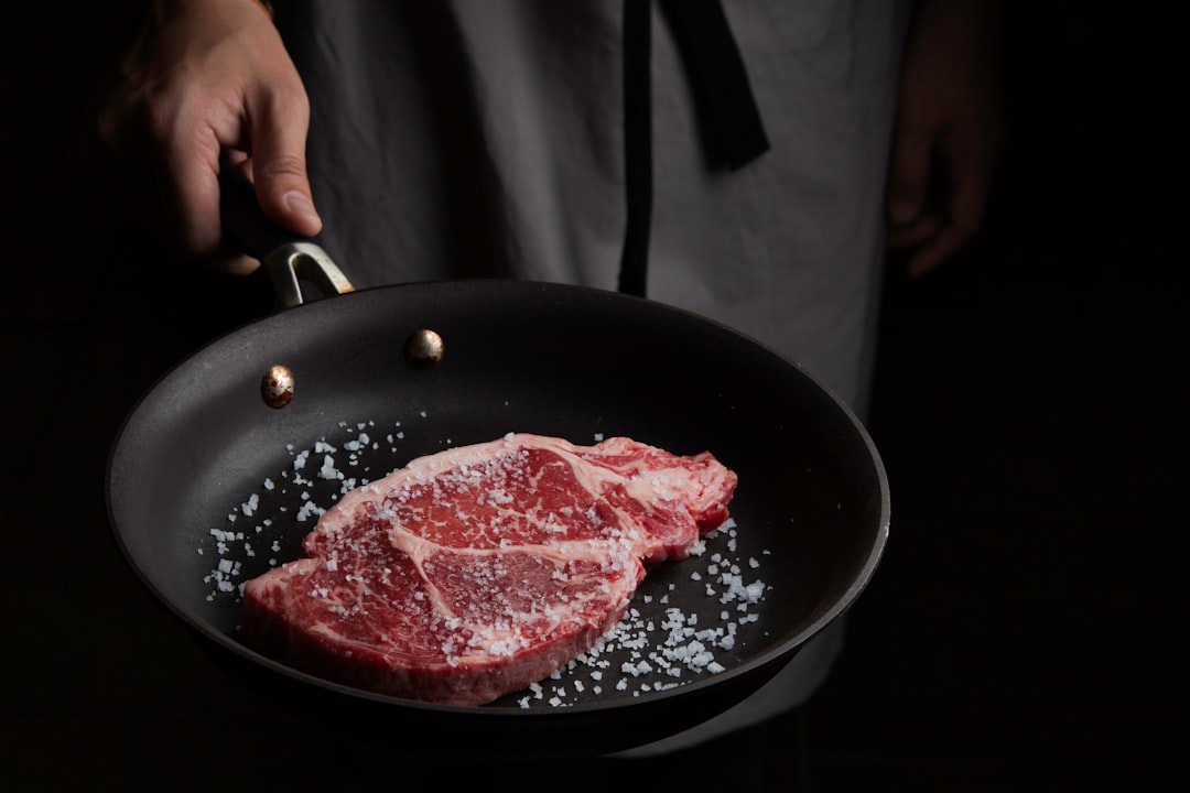 Chef searing steak in skillet