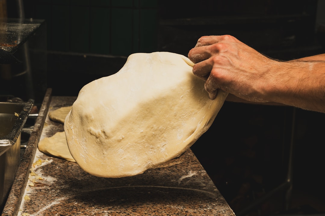 Hands stretching pizza dough for homemade pizza