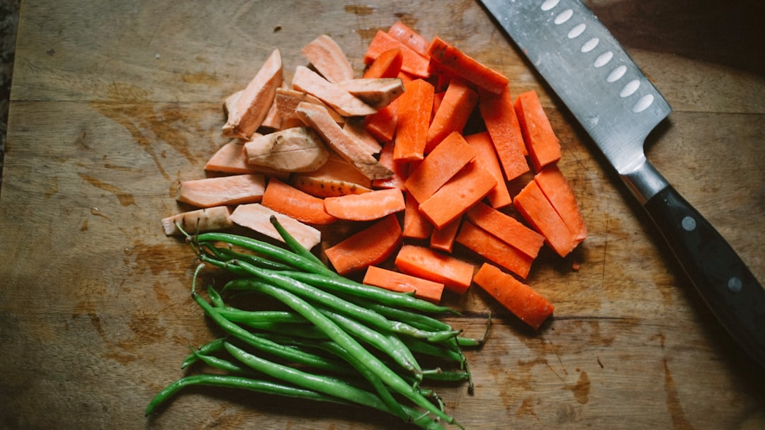 Santoku knife dicing fresh vegetables on cutting board
