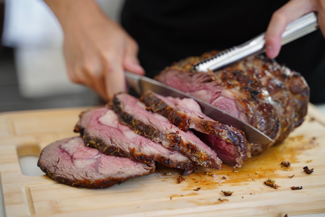 slicing rested roast on wooden cutting board