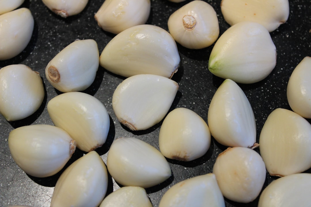 Fresh garlic cloves on a wooden cutting board ready for peeling