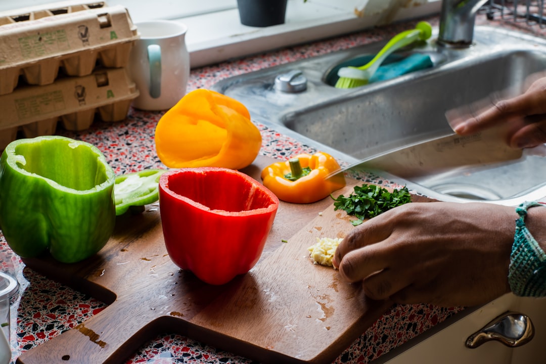 wooden cutting board over kitchen sink with fresh vegetables