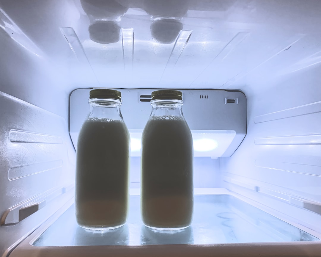 Glass juice bottles lined up in a refrigerator