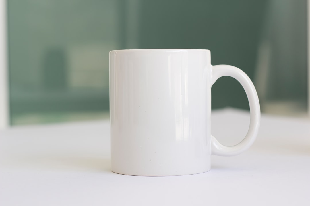 Set of white ceramic coffee mugs with embossed texture on a kitchen counter