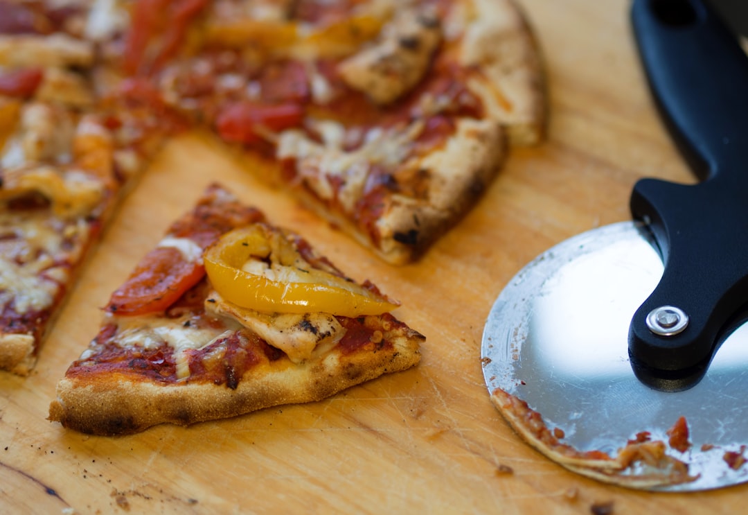 Rocker pizza cutter slicing through a freshly baked pizza