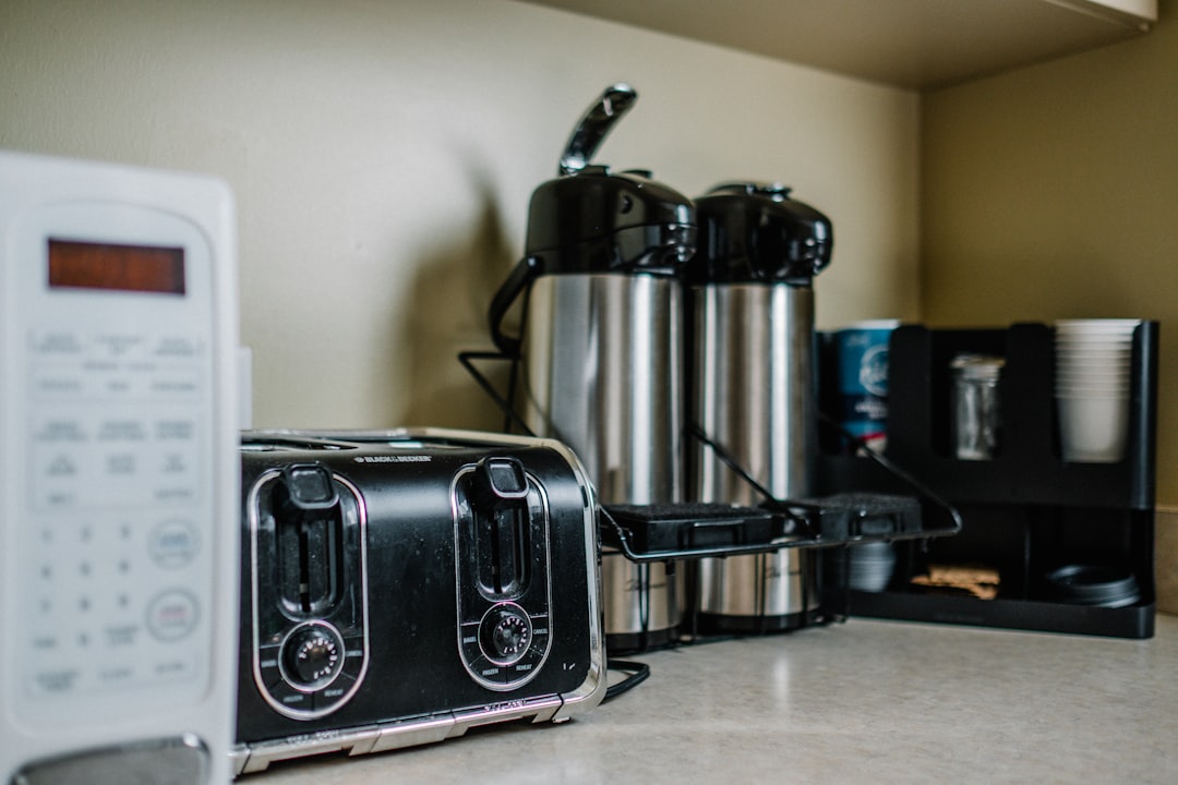 Coffee maker on a sliding tray under kitchen cabinet