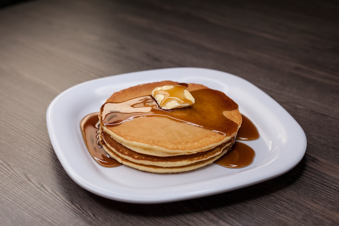 Pancakes cooking on a griddle with golden brown edges