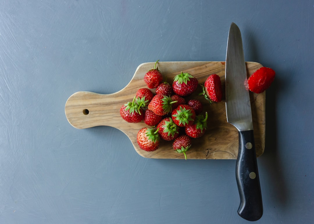 Paring knife with fresh strawberries on a cutting board