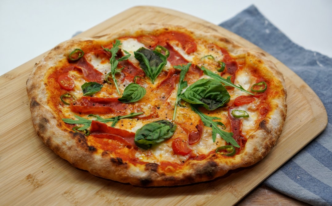 Fresh basil leaves on a pizza with melted cheese and tomatoes
