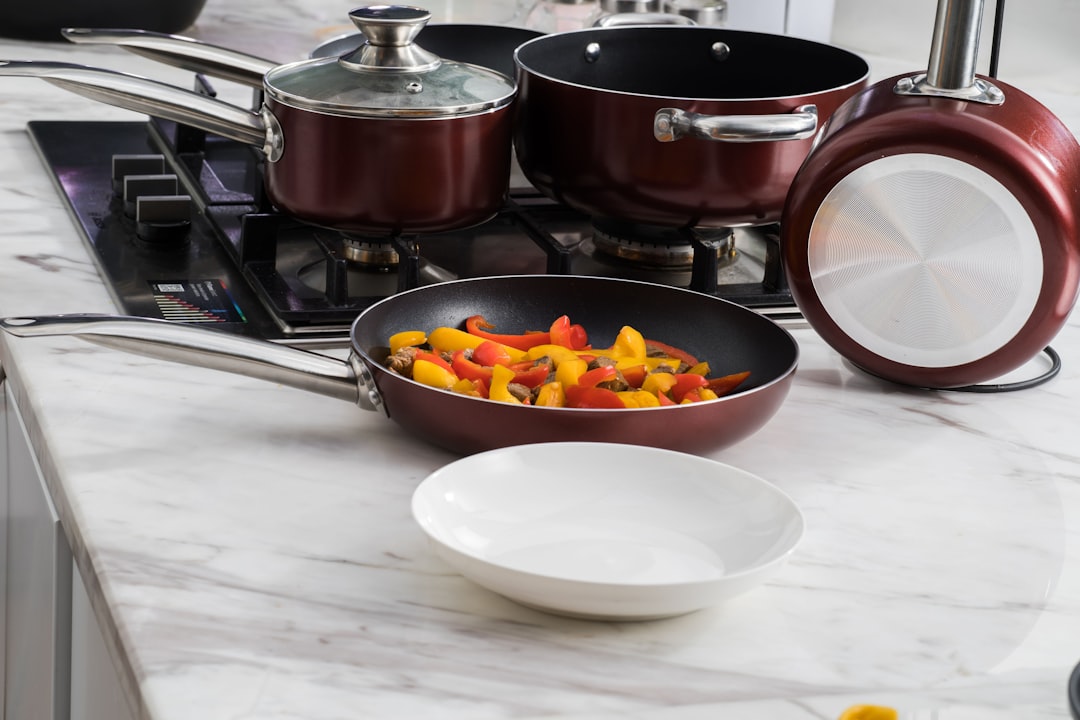 White ceramic cookware pans arranged on a kitchen counter