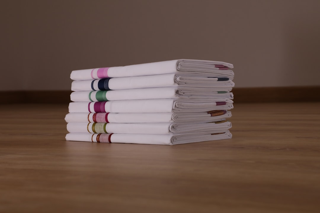 Neatly stacked cotton kitchen dish towels in neutral tones