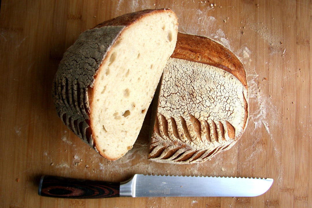 Bread knife slicing through a crusty sourdough loaf