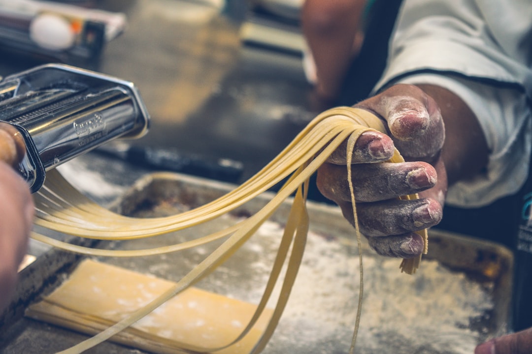 Fresh pasta dough being rolled out on kitchen counter