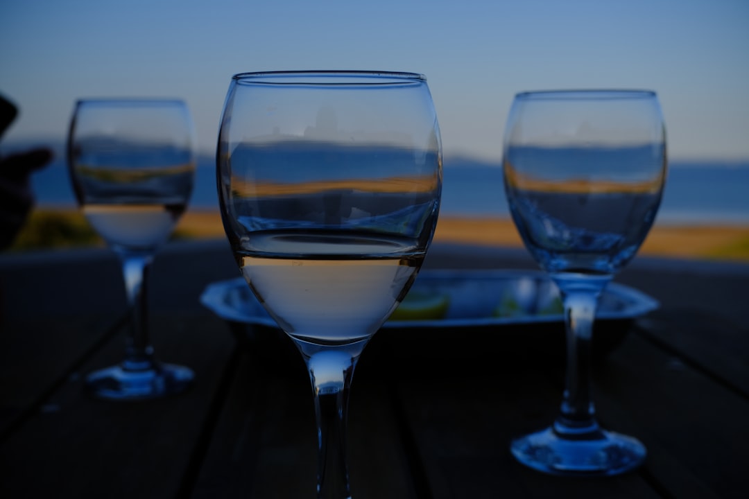 Plastic wine glasses on a patio table at dusk