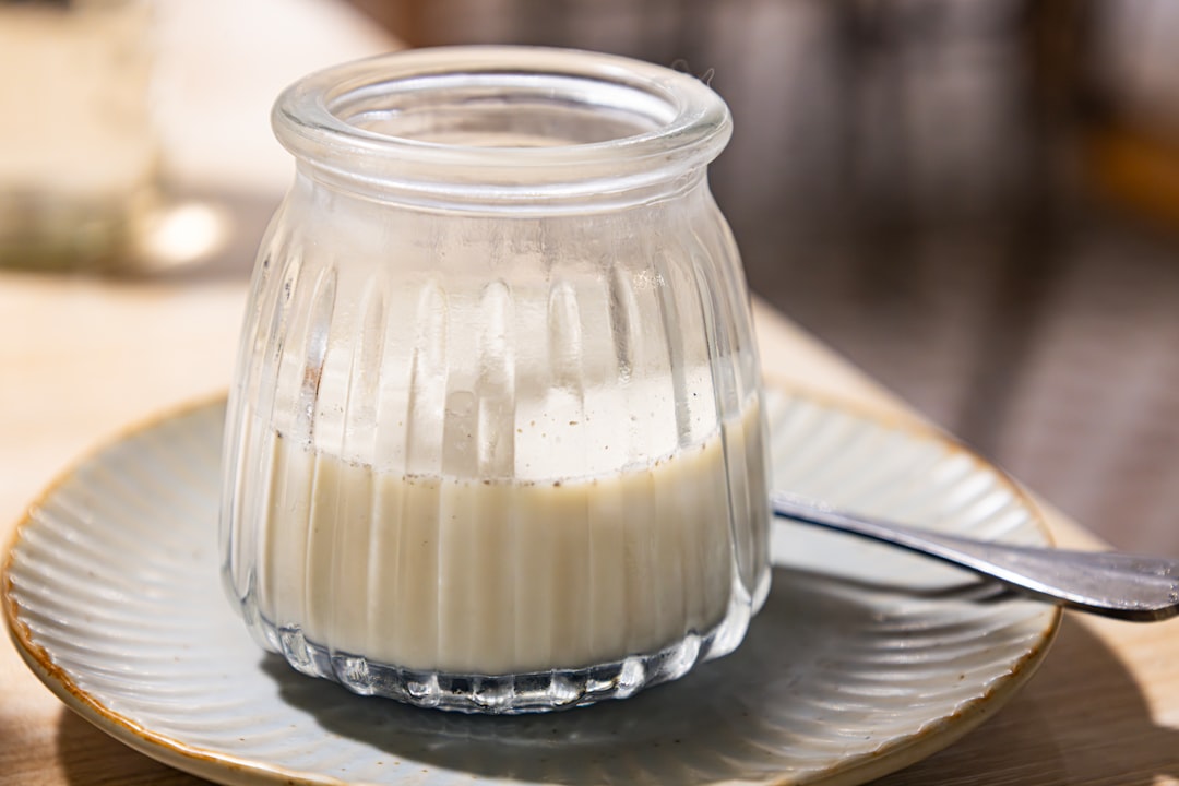 Homemade mayonnaise in a glass jar with fresh herbs