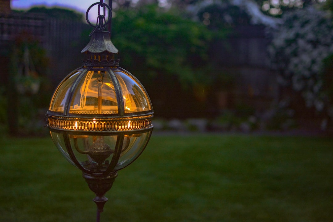 Outdoor candles and lanterns glowing in a garden at evening