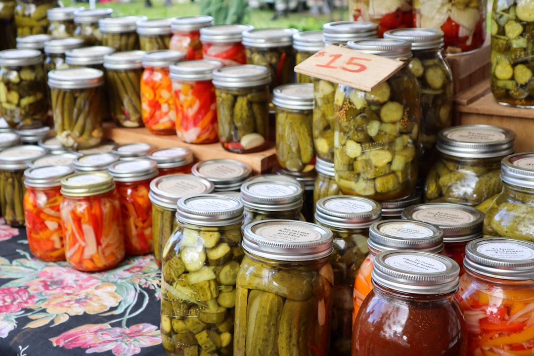 Mason jars filled with preserved tomatoes on a pantry shelf
