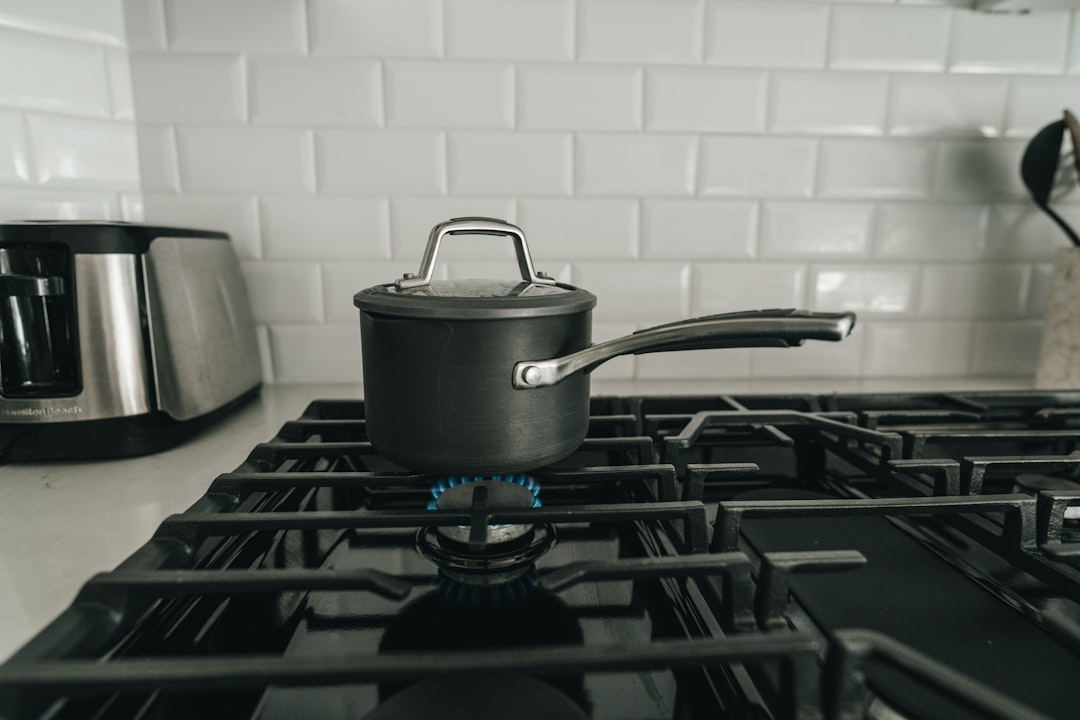 Creamy tomato soup simmering on a stove in a Dutch oven