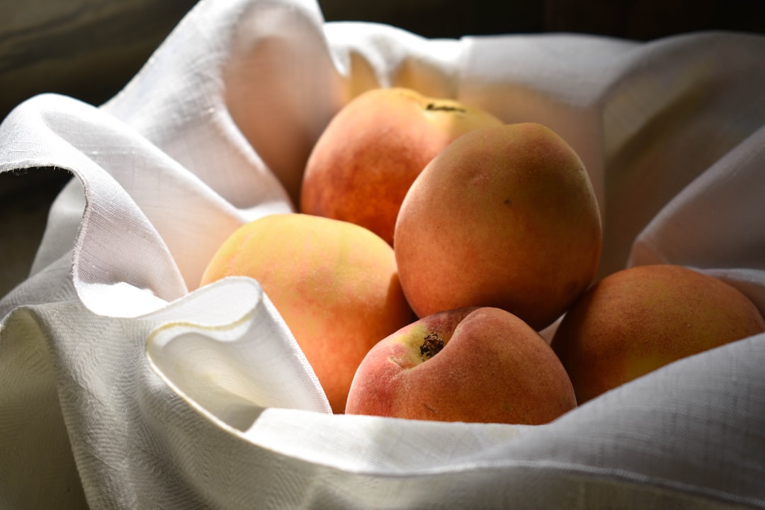 A bowl of ripe summer peaches on a kitchen counter
