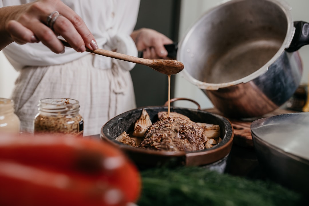 Tasting food from a wooden spoon in the kitchen