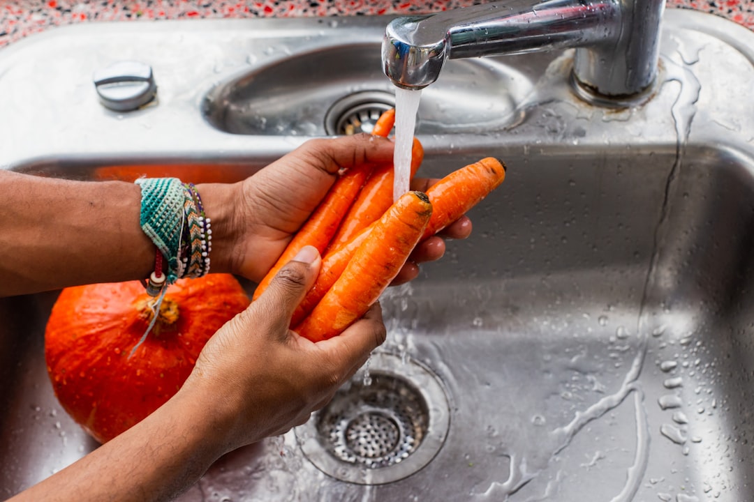 Fresh vegetables being washed in the kitchen sink