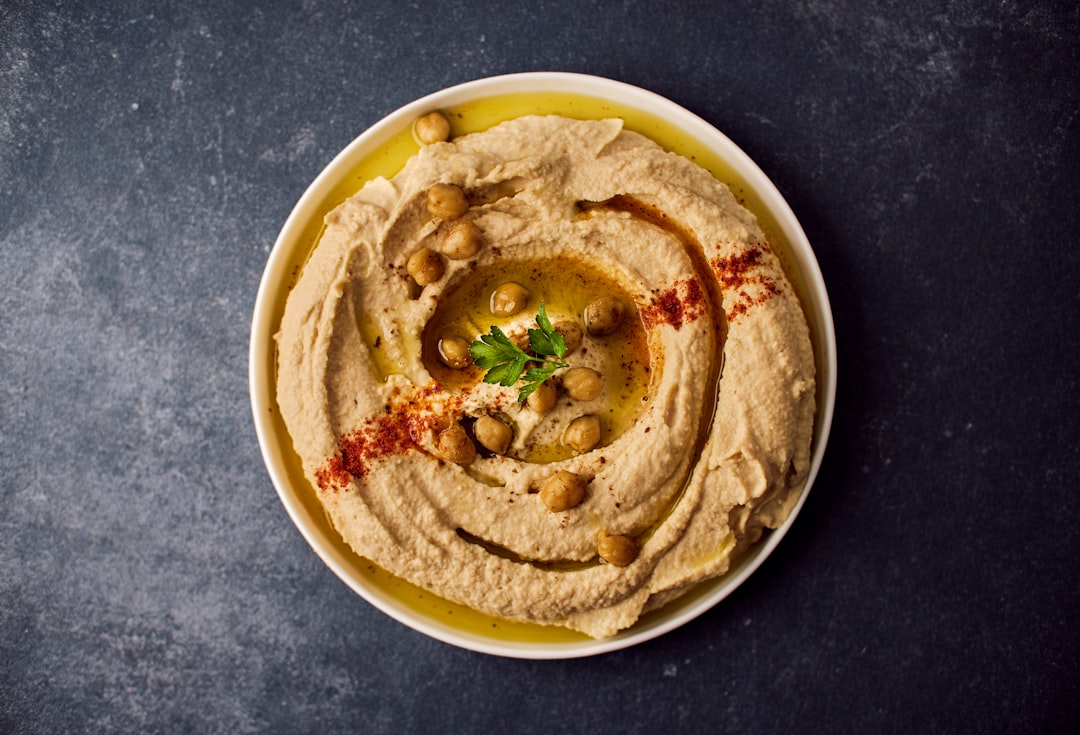 Creamy homemade hummus topped with olive oil in a bowl