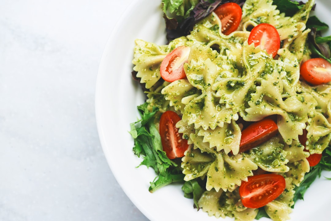 Pasta salad with pesto, tomatoes and greens packed for lunch