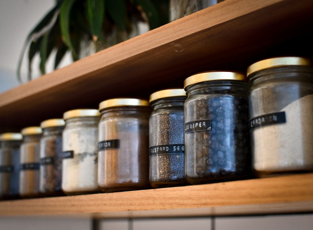 Glass jars of home-dried herbs arranged on a kitchen shelf