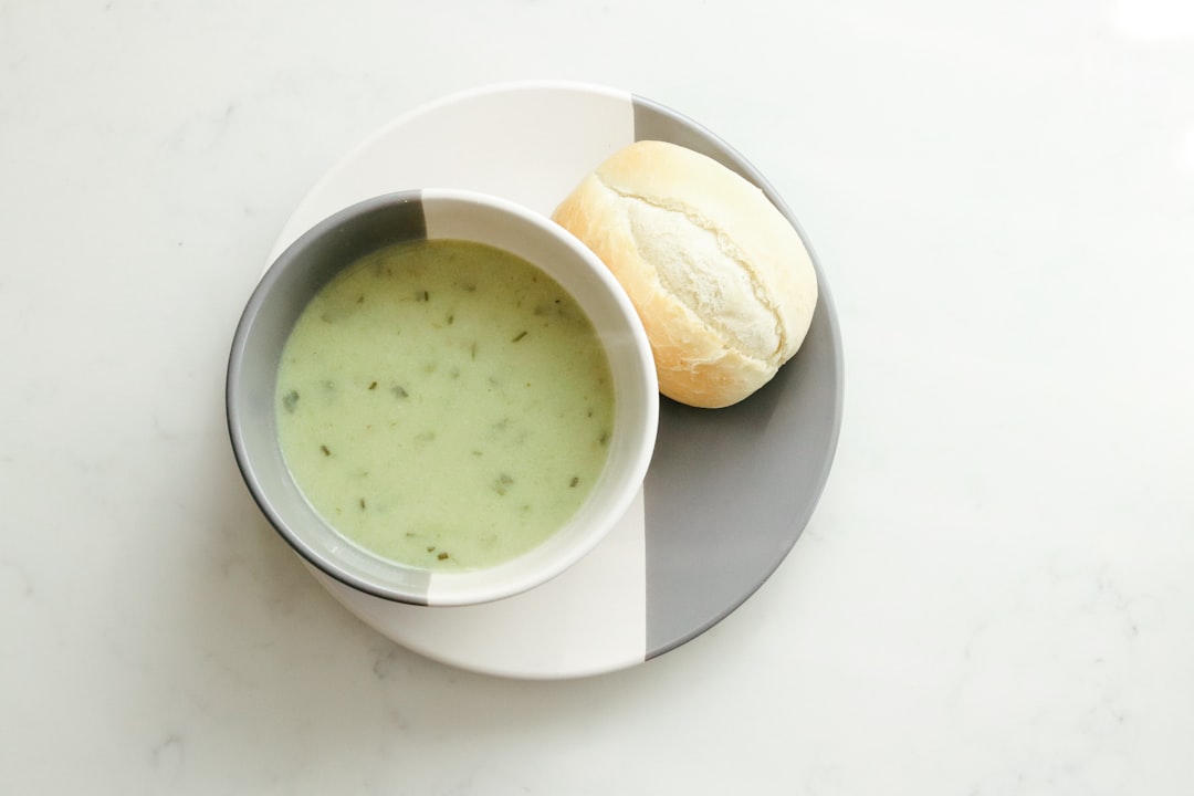Bowl of hot soup beside bread, the kind of lunch that travels well in an insulated food jar