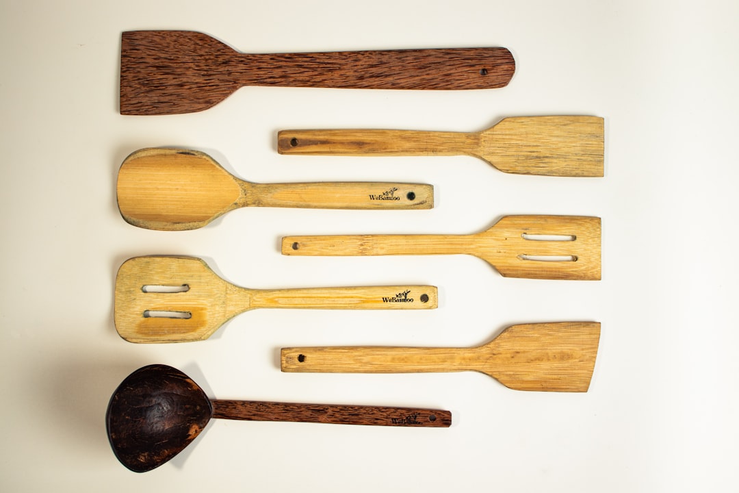 Flat wooden spatula scraping fond from a well-used skillet