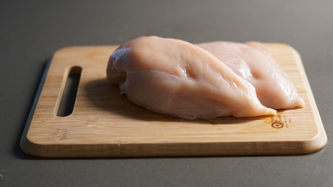 Chicken breast searing golden in a stainless steel pan