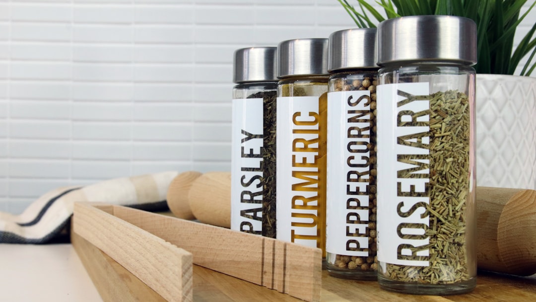 Organized spice rack inside a kitchen cabinet showing tiered arrangement of jars