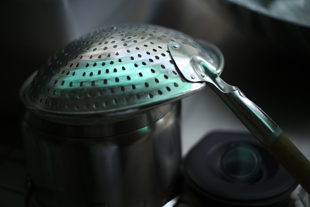 Stainless steel colander resting over a pot