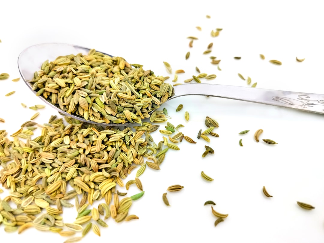 Whole cumin seeds in a wooden spoon