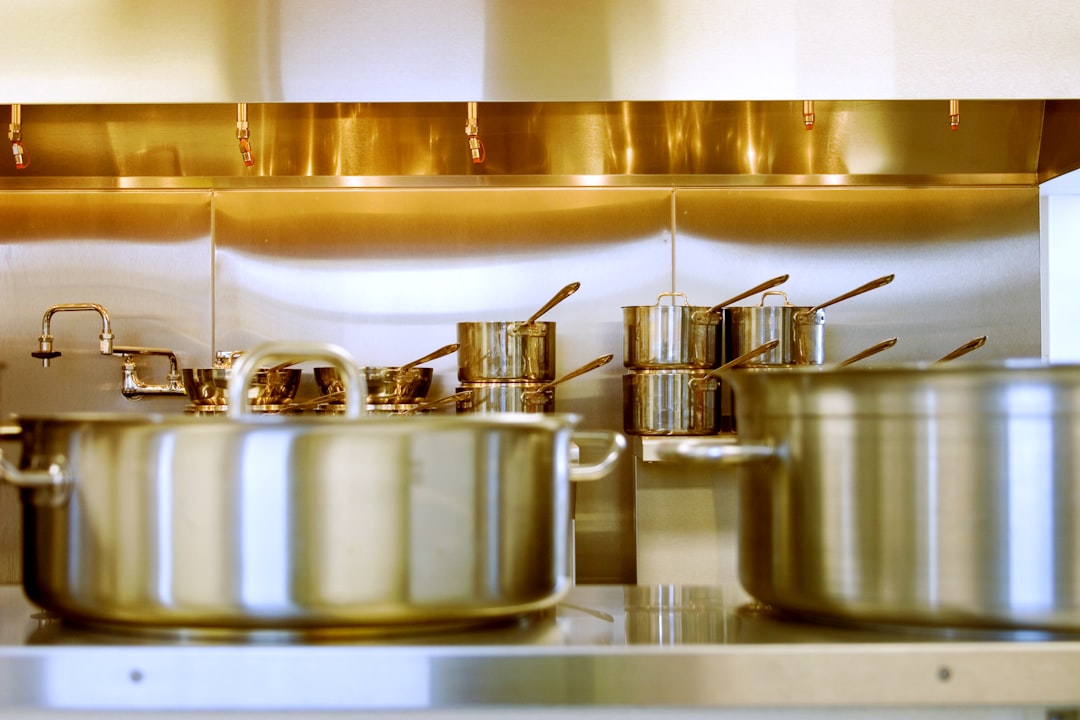 Stainless steel pots and pans stacked in a kitchen