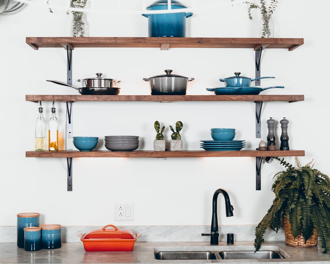 Wall mounted pot rack with hanging cookware in kitchen