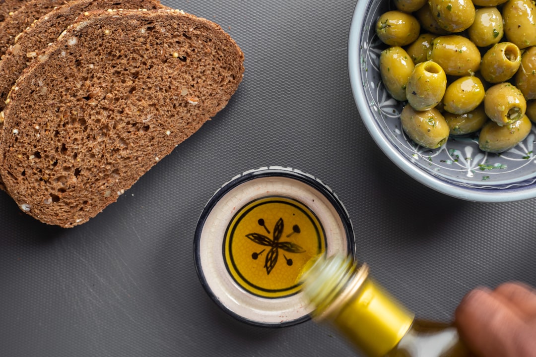 Olive oil being poured over bread and olives