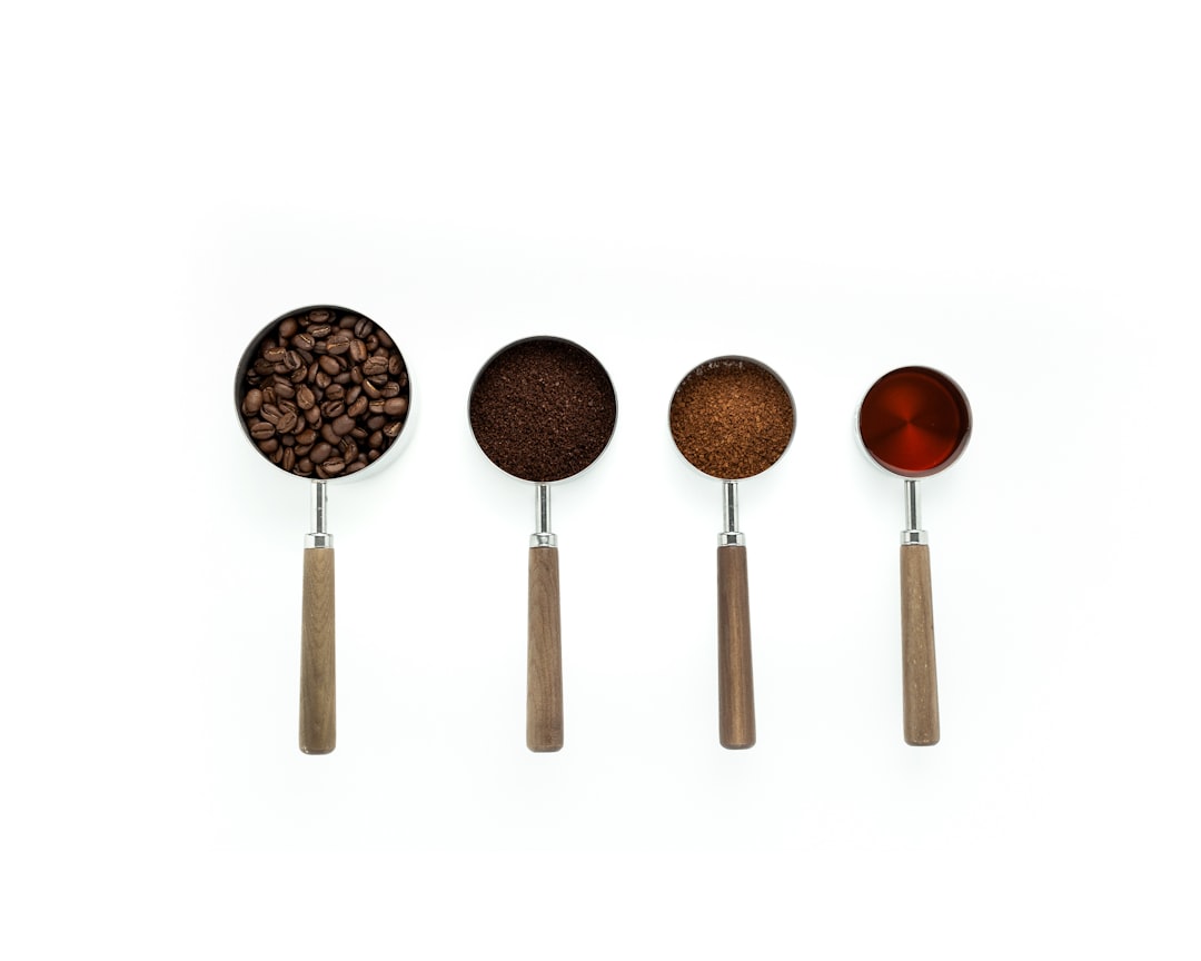 Measuring spoons portioning fresh coffee grounds for brewing