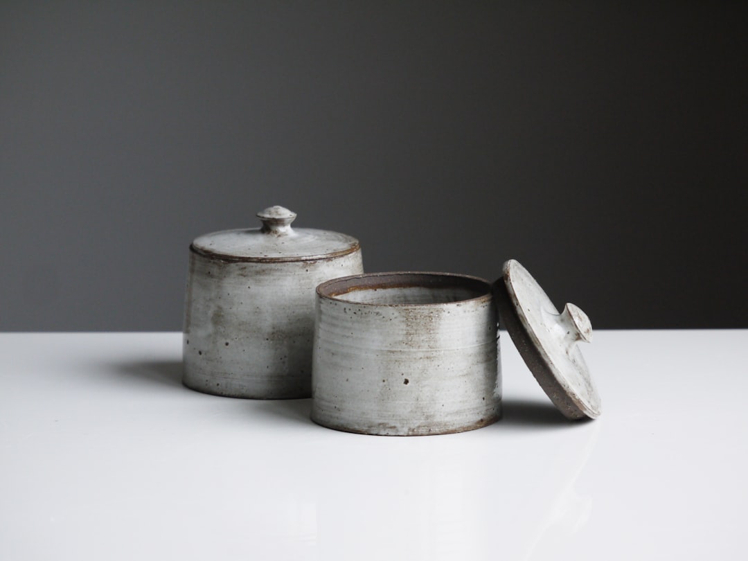 Two rustic ceramic lidded jars on a counter