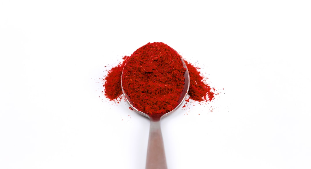A measuring spoon with red paprika spice