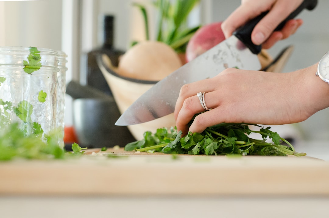 Kitchen shears snipping fresh herbs over a cutting board