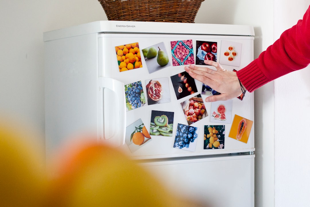 Hand updating magnetic list on refrigerator door