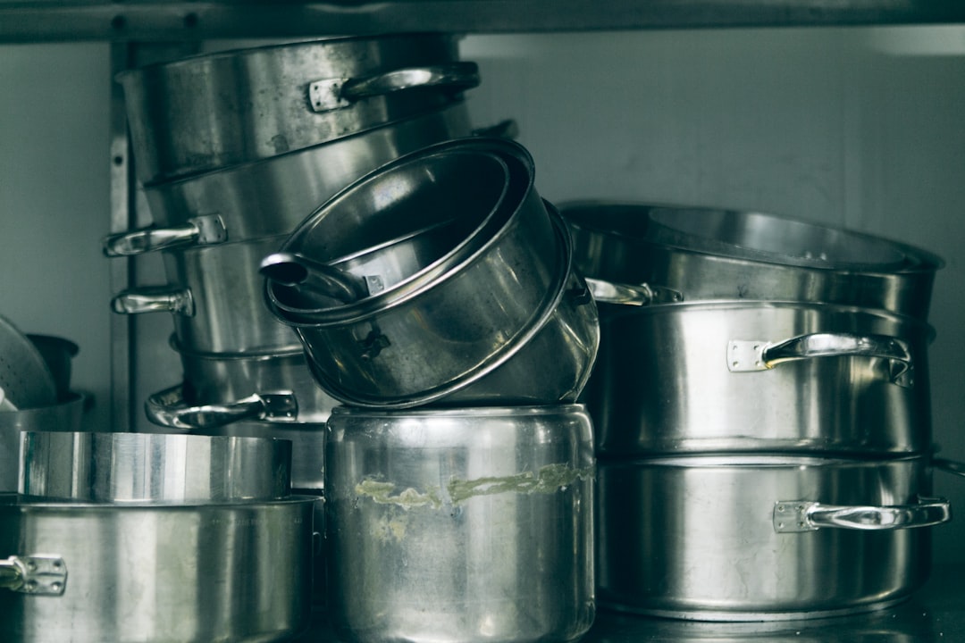 Pots and pans stacked neatly inside a kitchen cabinet