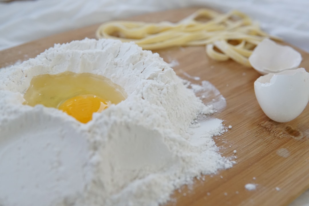 Eggs cracked into a well of flour, ready to become fresh pasta dough