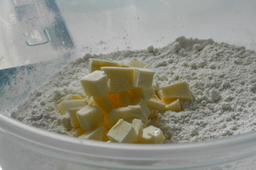 A mixing bowl of flour with cold cubed butter, ready for pie dough