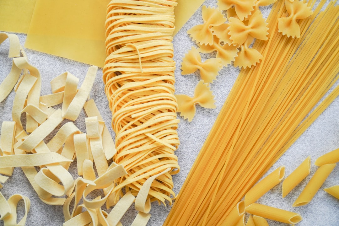 Assorted raw pasta shapes and a bundle of fresh tagliatelle