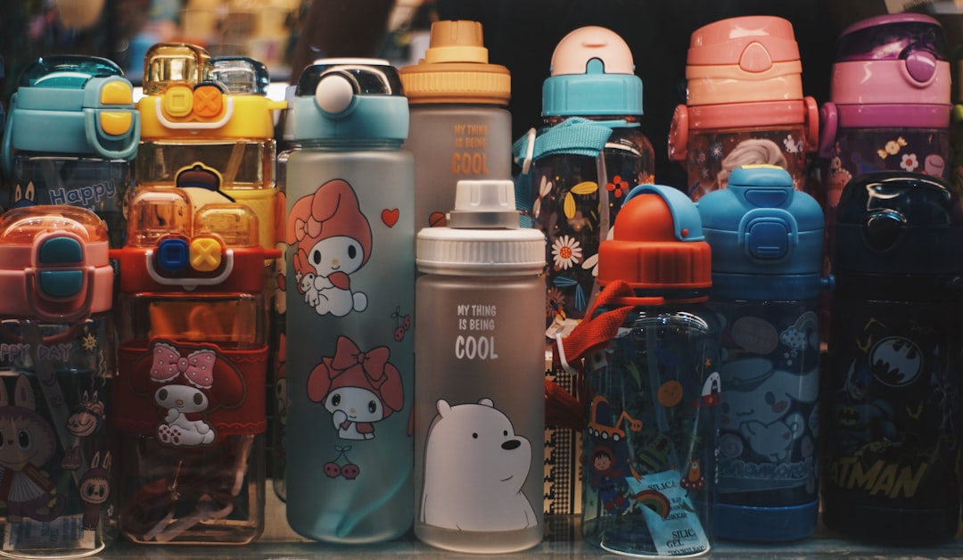 Colorful kids water bottles lined up on a counter